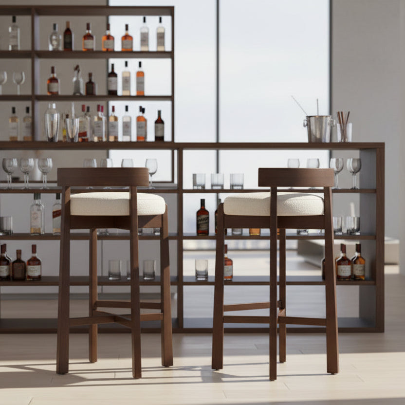 Wooden bar stool with beige cushioned seat in a room setting.